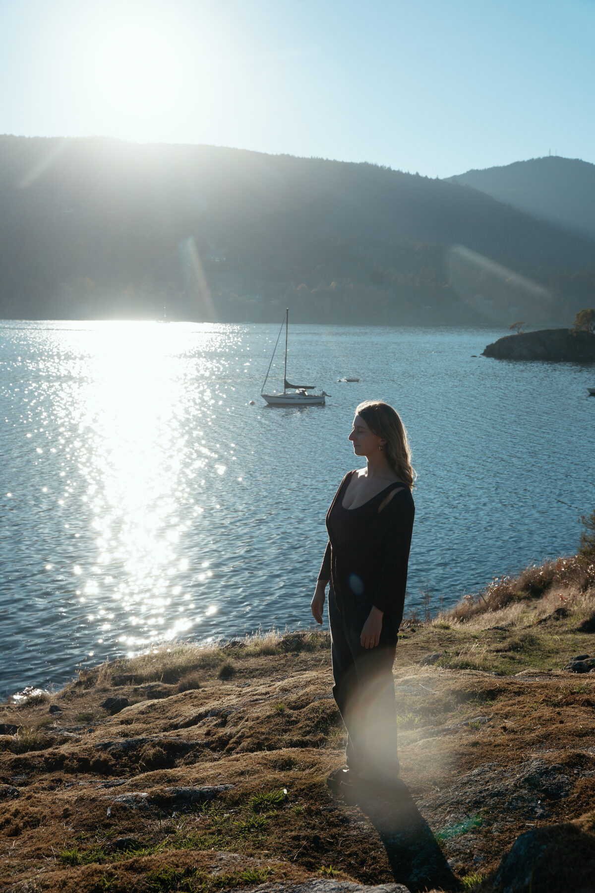 Zoe standing by the ocean at sunset